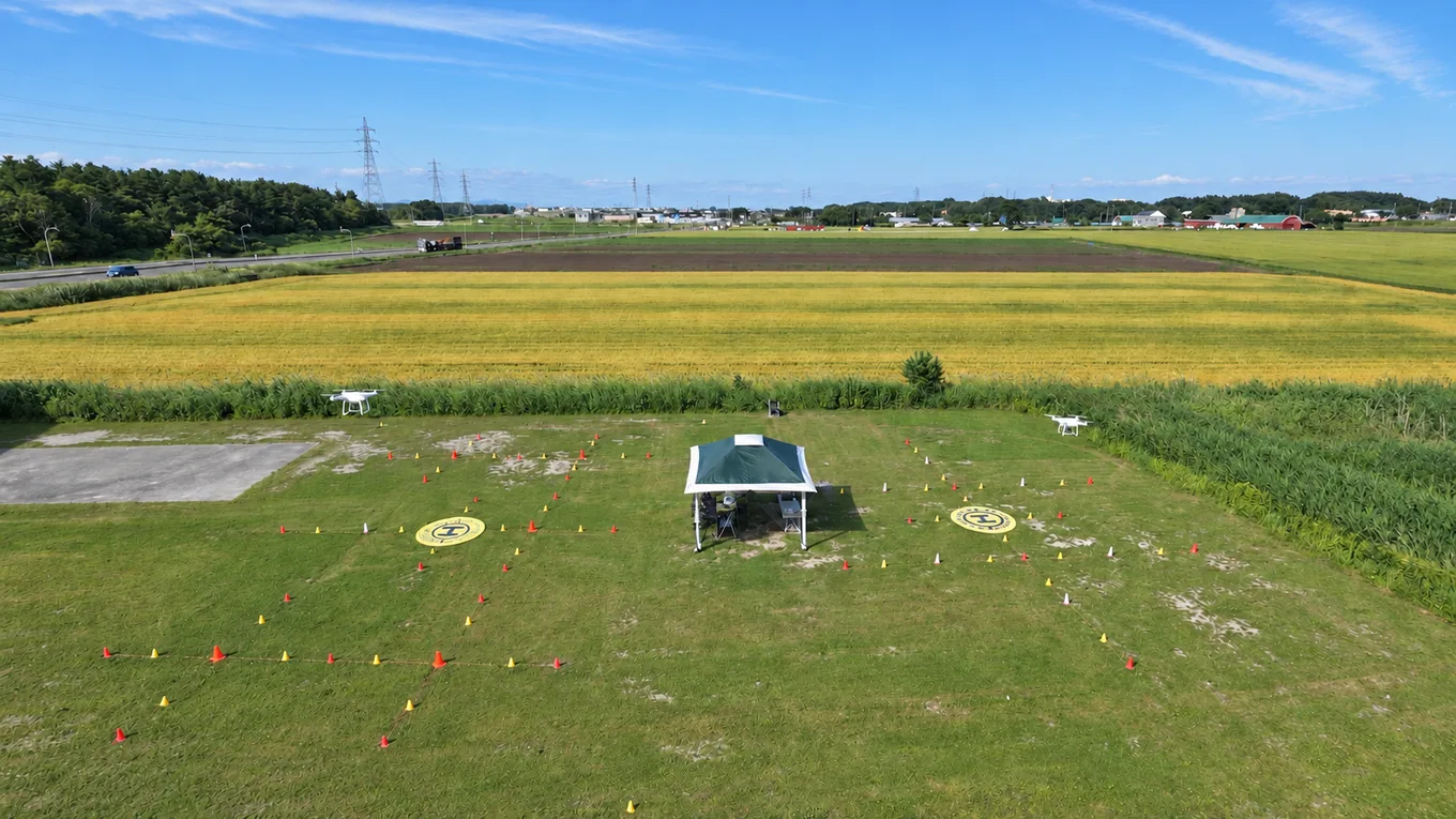 スカイシャッターの屋外飛行エリア。離着陸場所とコーンを配置した全景。明るさ・色調をAI補正した写真。